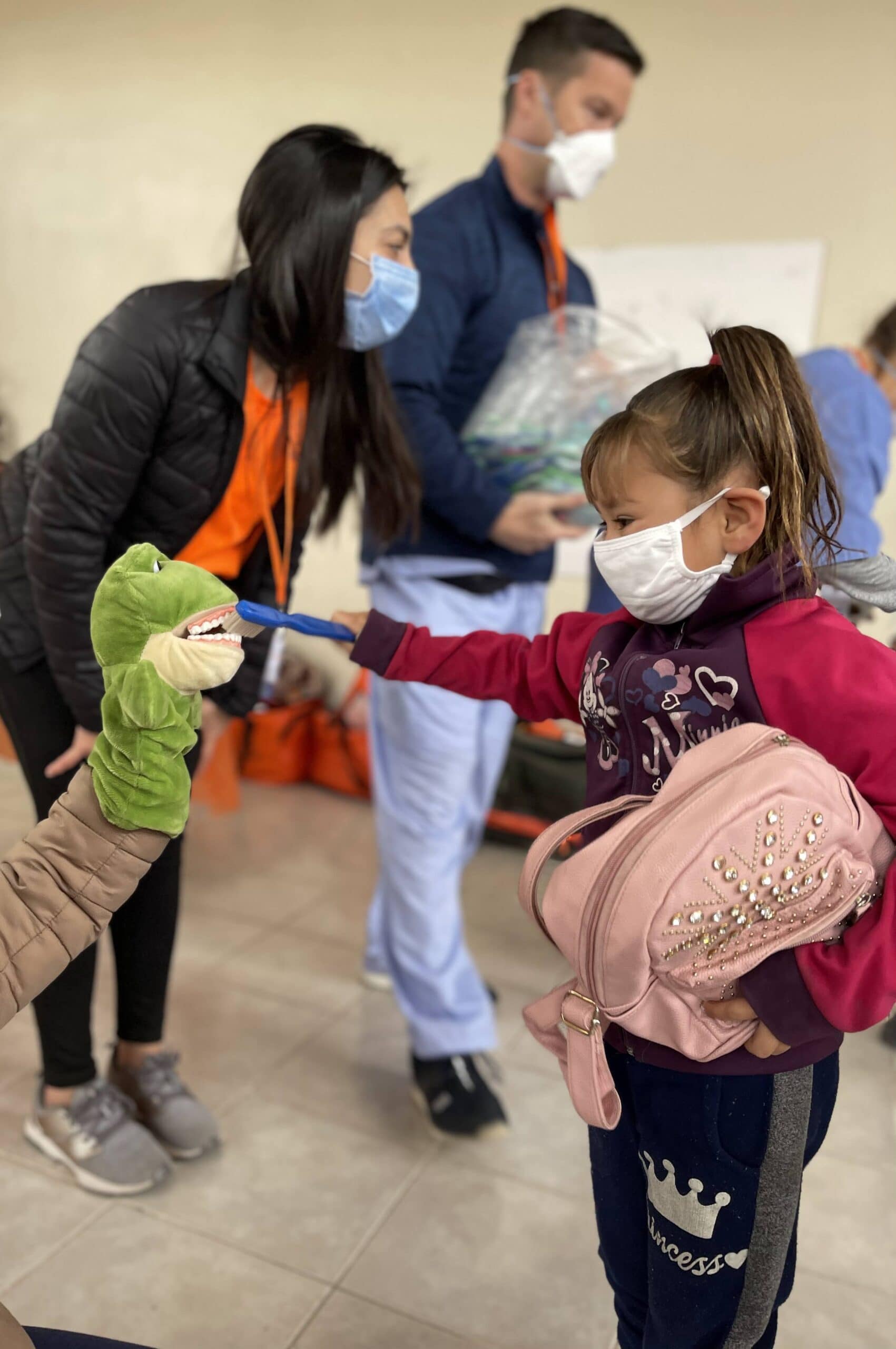 Girl in mask brush's puppets teeth